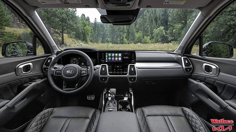 Looking forward at the dashboard from the rear seat inside the 2022 Kia Sorento SX.